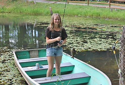 Girl on a boat with a fish on the line